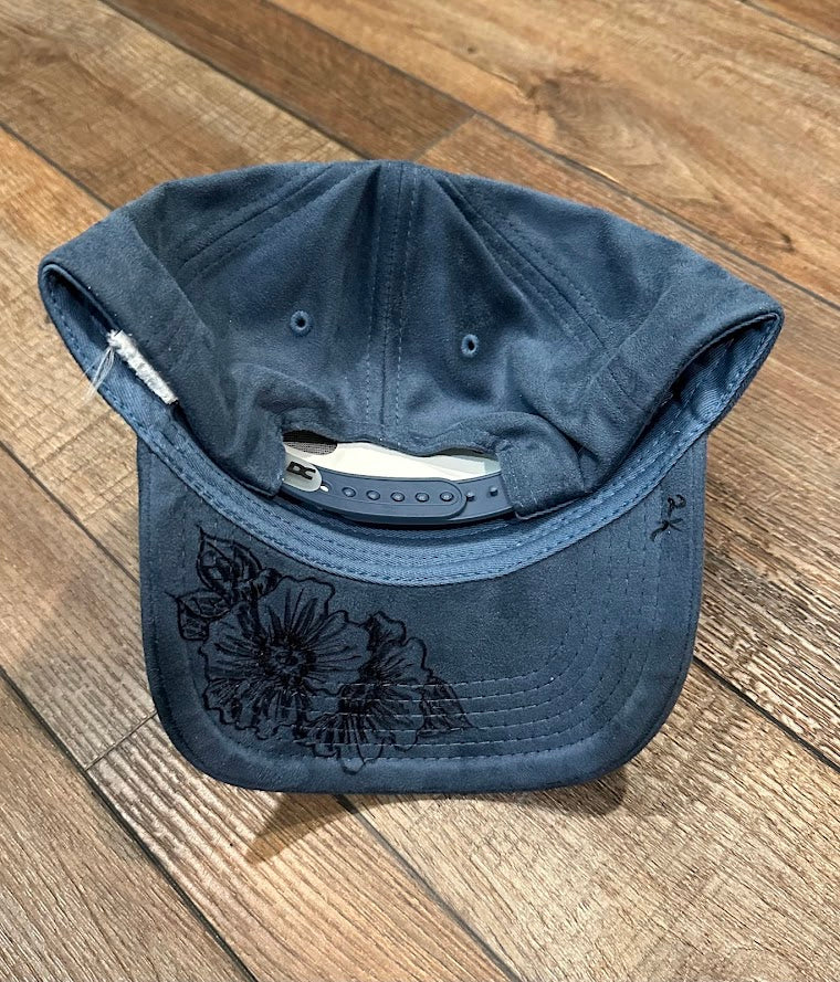 Blue cap with floral embroidery on a wooden floor
