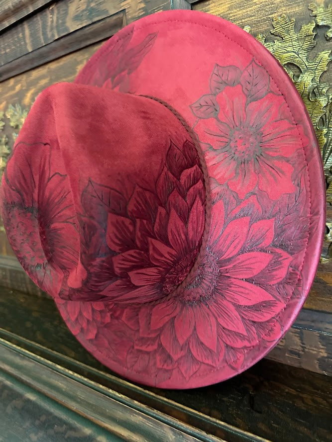 Red floral-patterned hat on a wooden surface