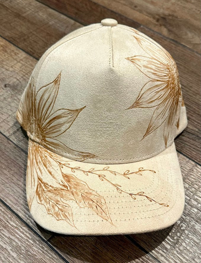 Beige cap with leaf designs on a wooden surface