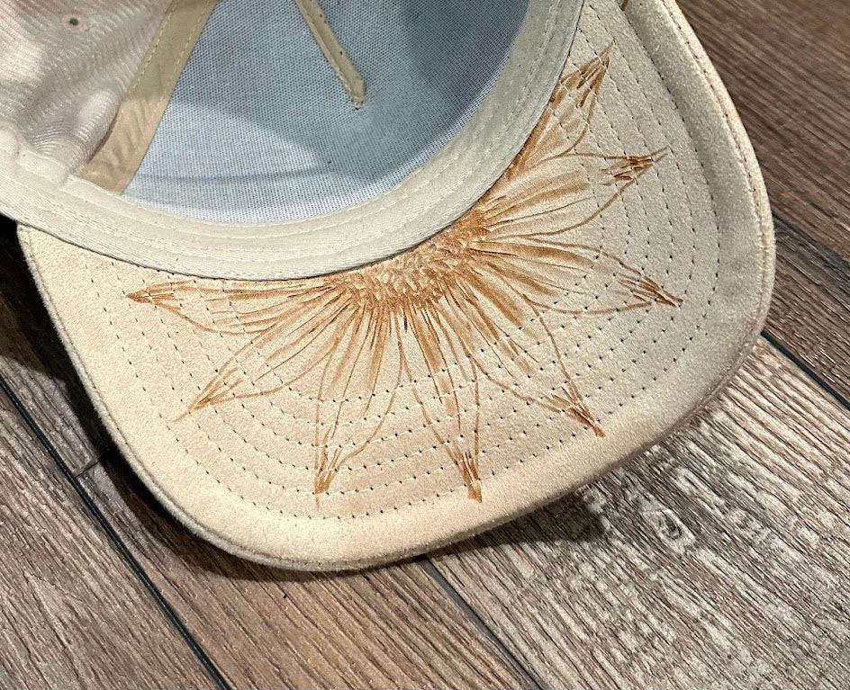 Beige sandal with floral embroidery on a wooden floor