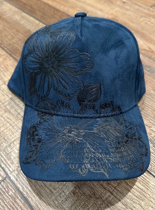 Blue cap with floral embroidery on a wooden surface