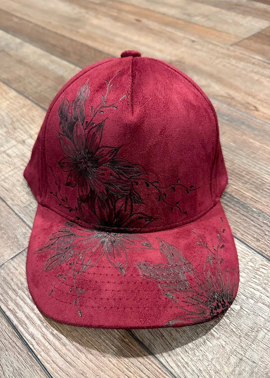 Red cap with black floral patterns on a wooden surface