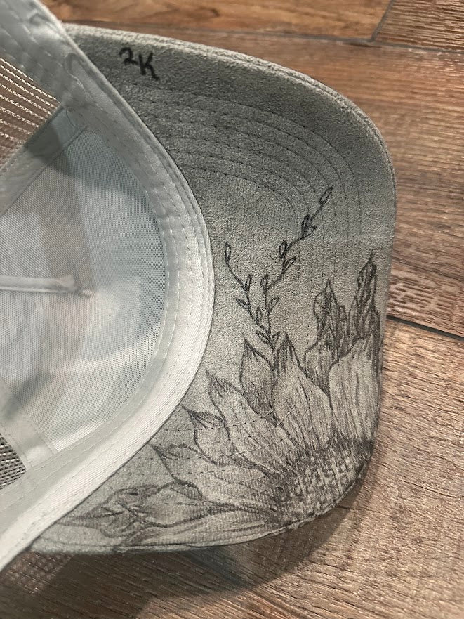 Gray cap with floral embroidery on a wooden surface