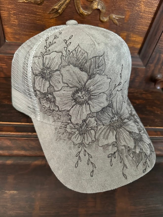 Gray cap with floral designs on a wooden surface