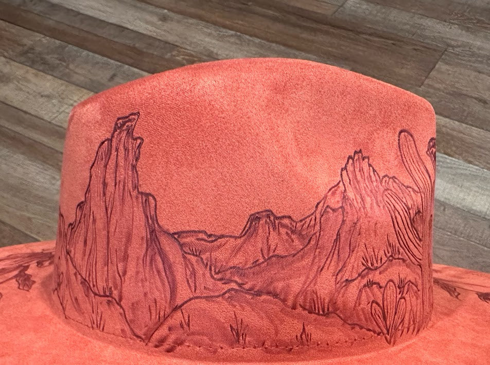 Red hat with mountain landscape design on a wooden surface