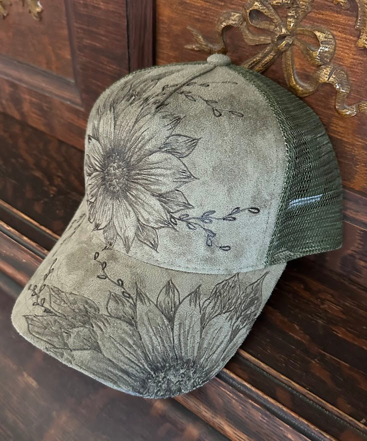 Green cap with floral designs on a wooden surface