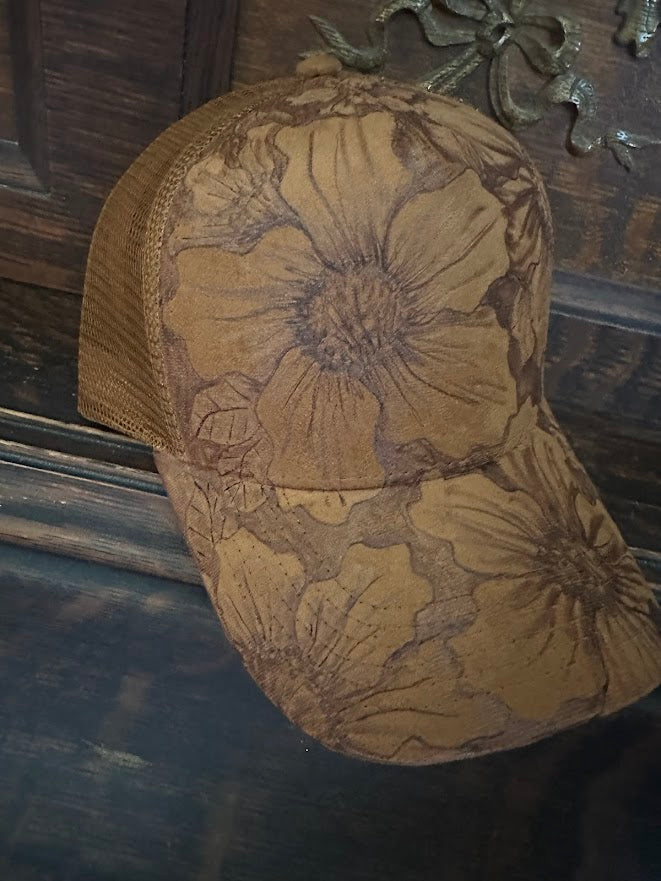 Brown baseball cap with floral patterns on a dark background