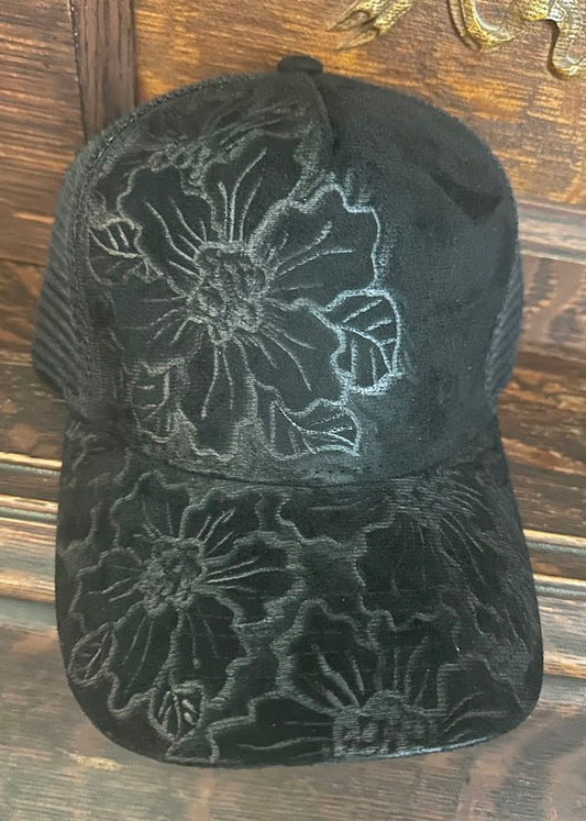 Black embroidered floral cap on a wooden surface