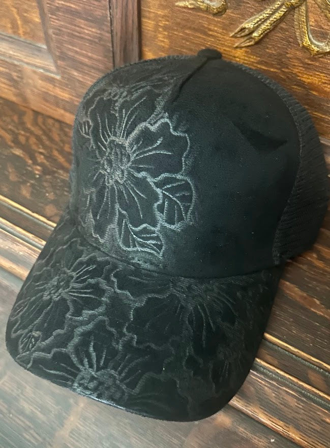 Black cap with floral patterns on a wooden surface