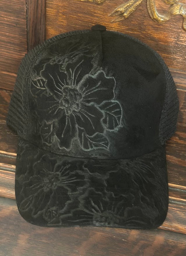 Black floral embroidered cap on a wooden surface