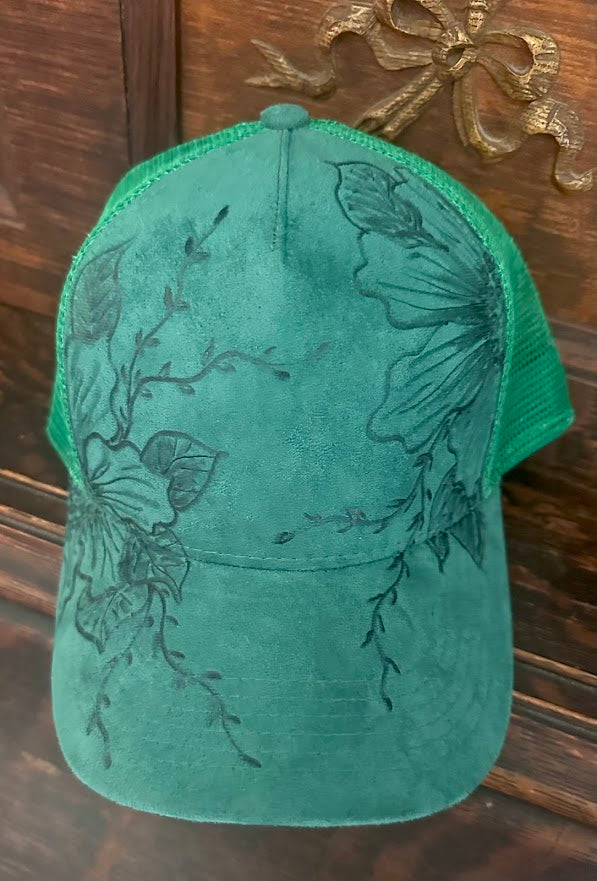 Green cap with floral designs on a wooden surface