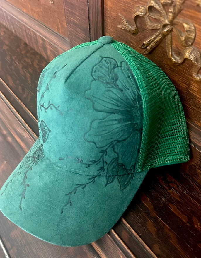 Green cap with floral embroidery on a wooden surface