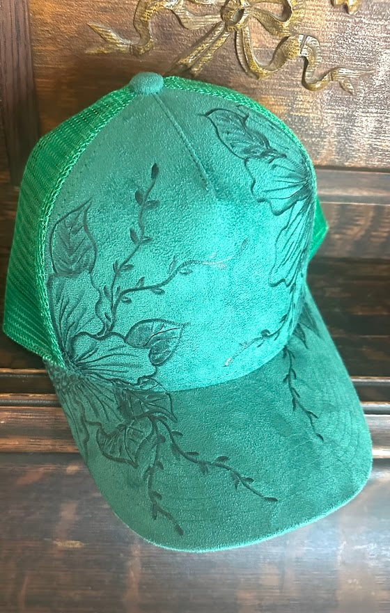 Green cap with floral embroidery on a wooden surface