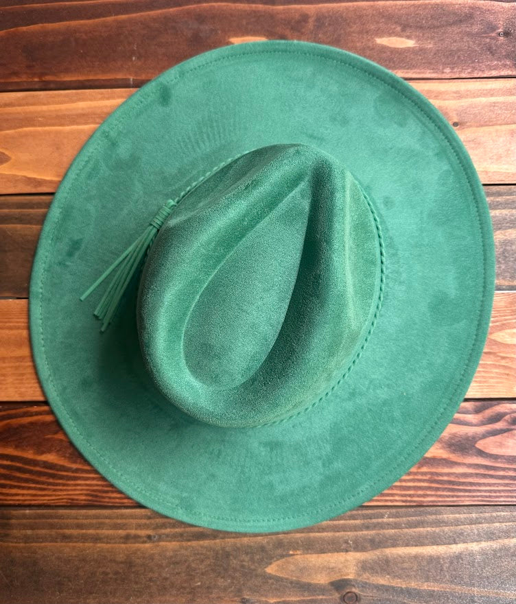 Green suede hat on a wooden surface