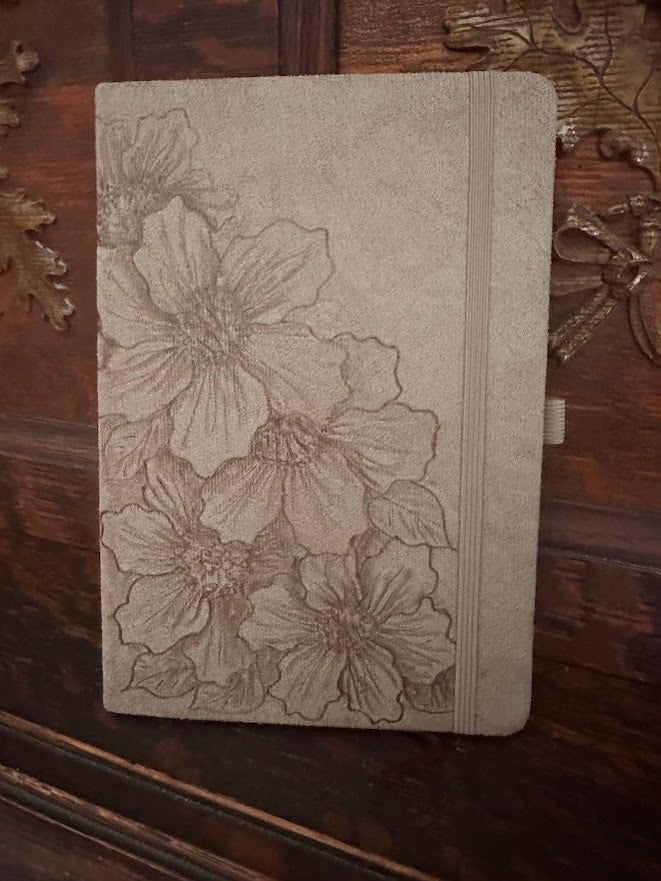 Floral embossed notebook on a wooden surface