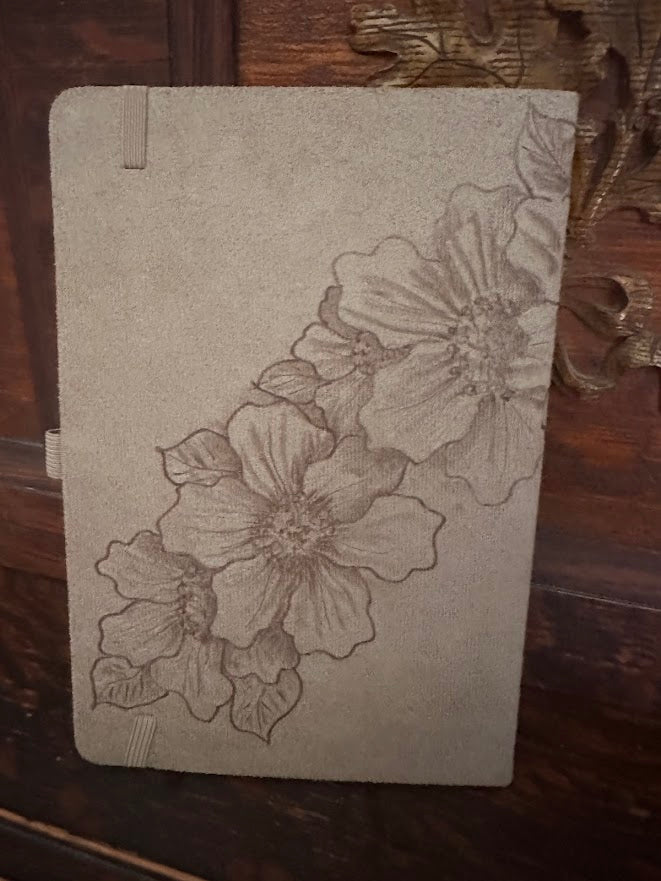 Notebook with floral design on a wooden surface