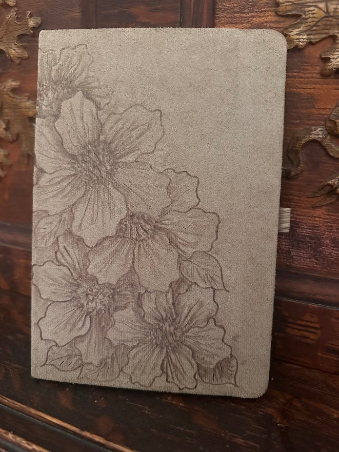 Floral embossed notebook on a wooden surface