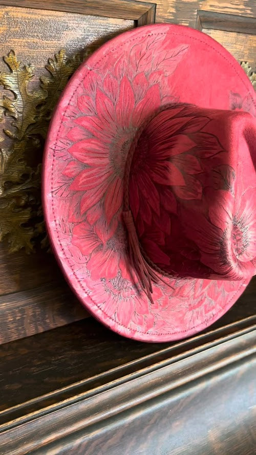 Red leather mug with floral design on a wooden surface